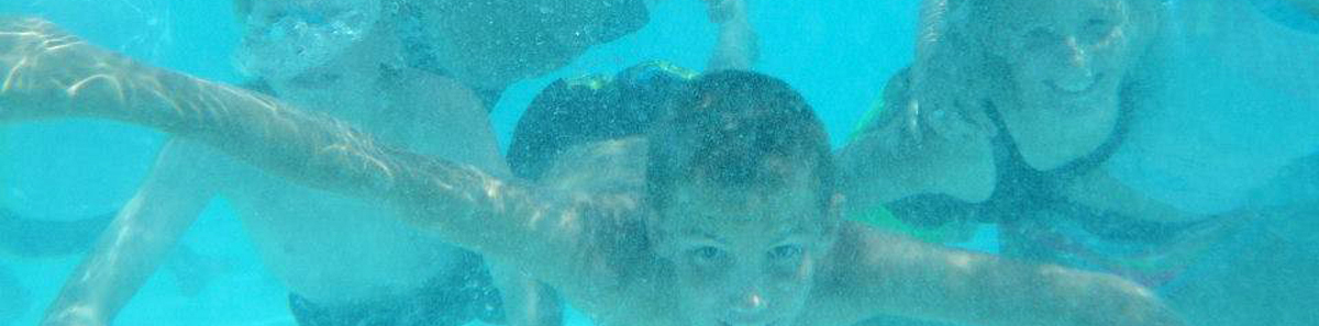 Picture of youth swimming underwater looking at the camera