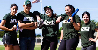 Group photo of softball employees in green shirts smiling