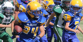 Picture of youth football players on field with opposing team.